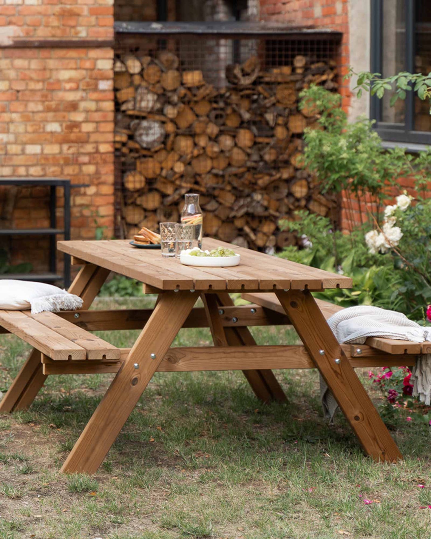 Brown wooden picnic table with minimal decor, set in a home garden
