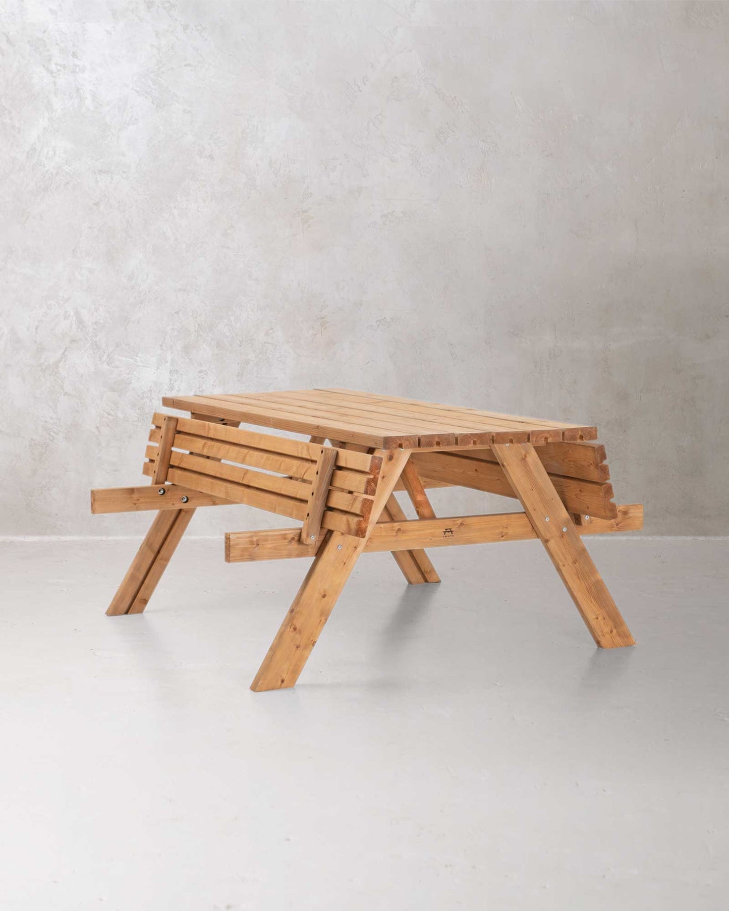 Brown wooden picnic table on a concrete background with both sides folded up