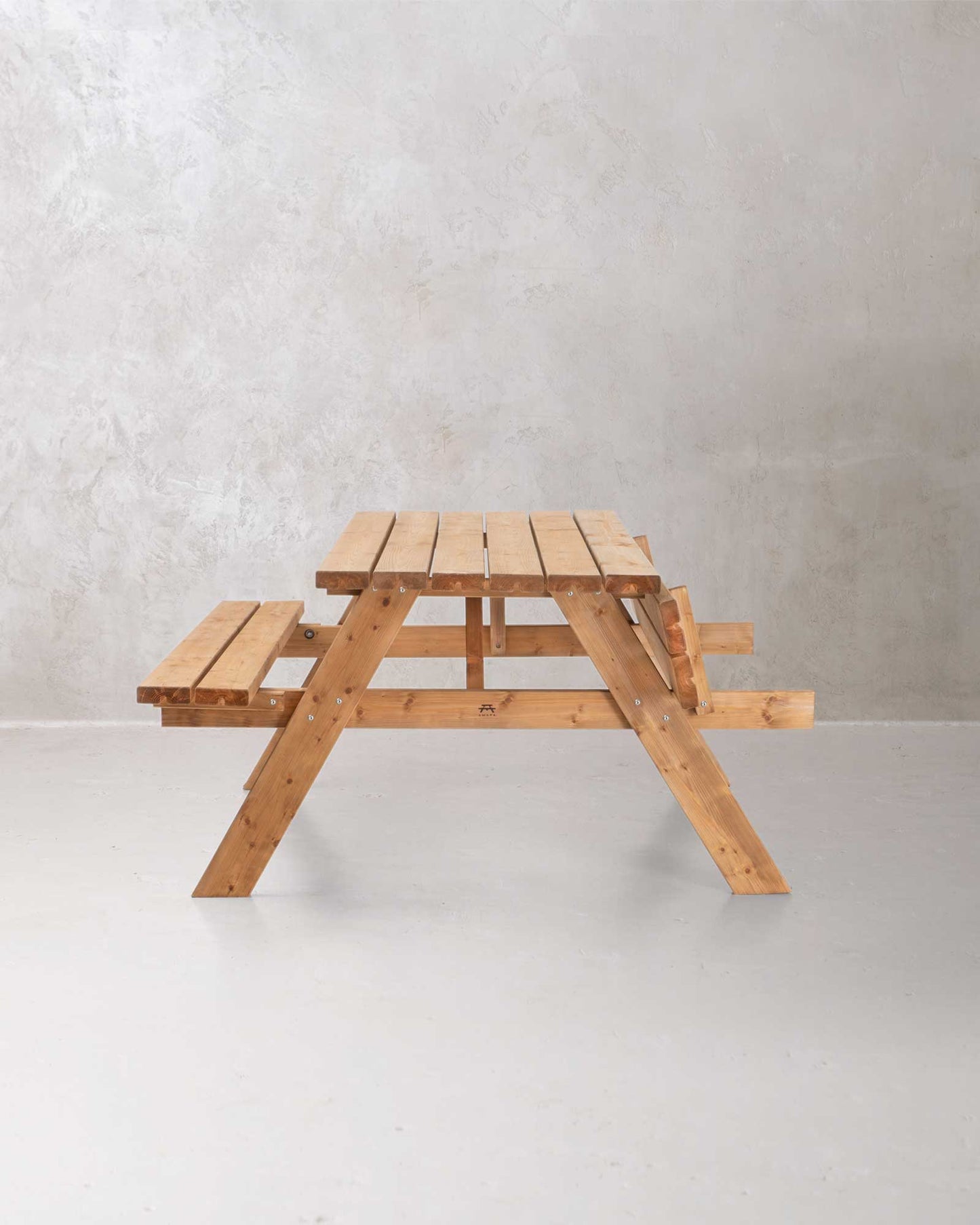 Brown wooden picnic table on a concrete background with one side folded up