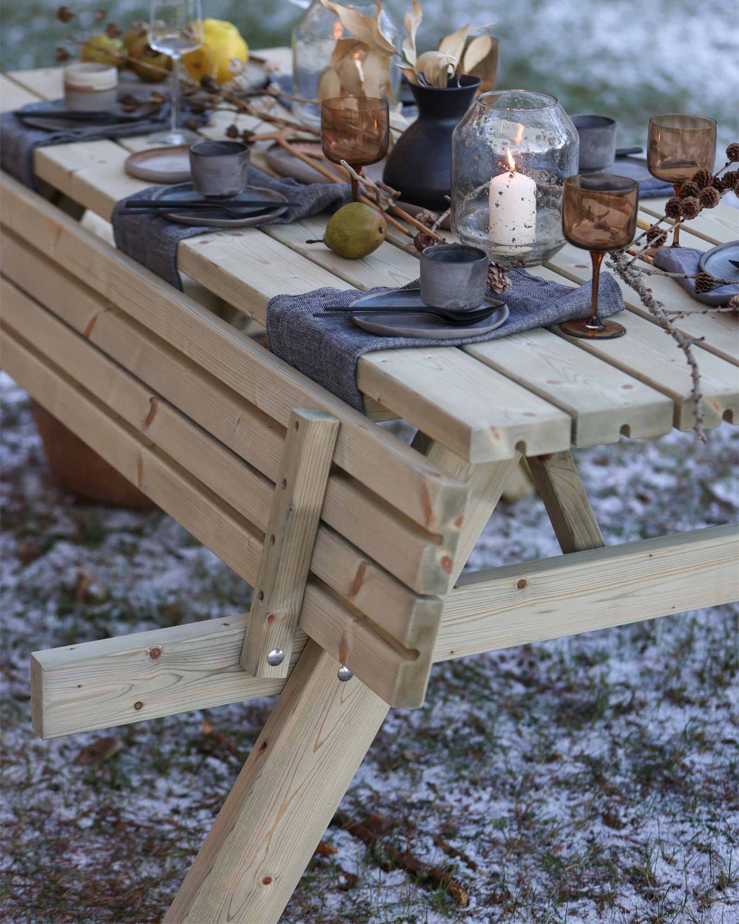 Beautifully set wooden picnic table in a frosty grass