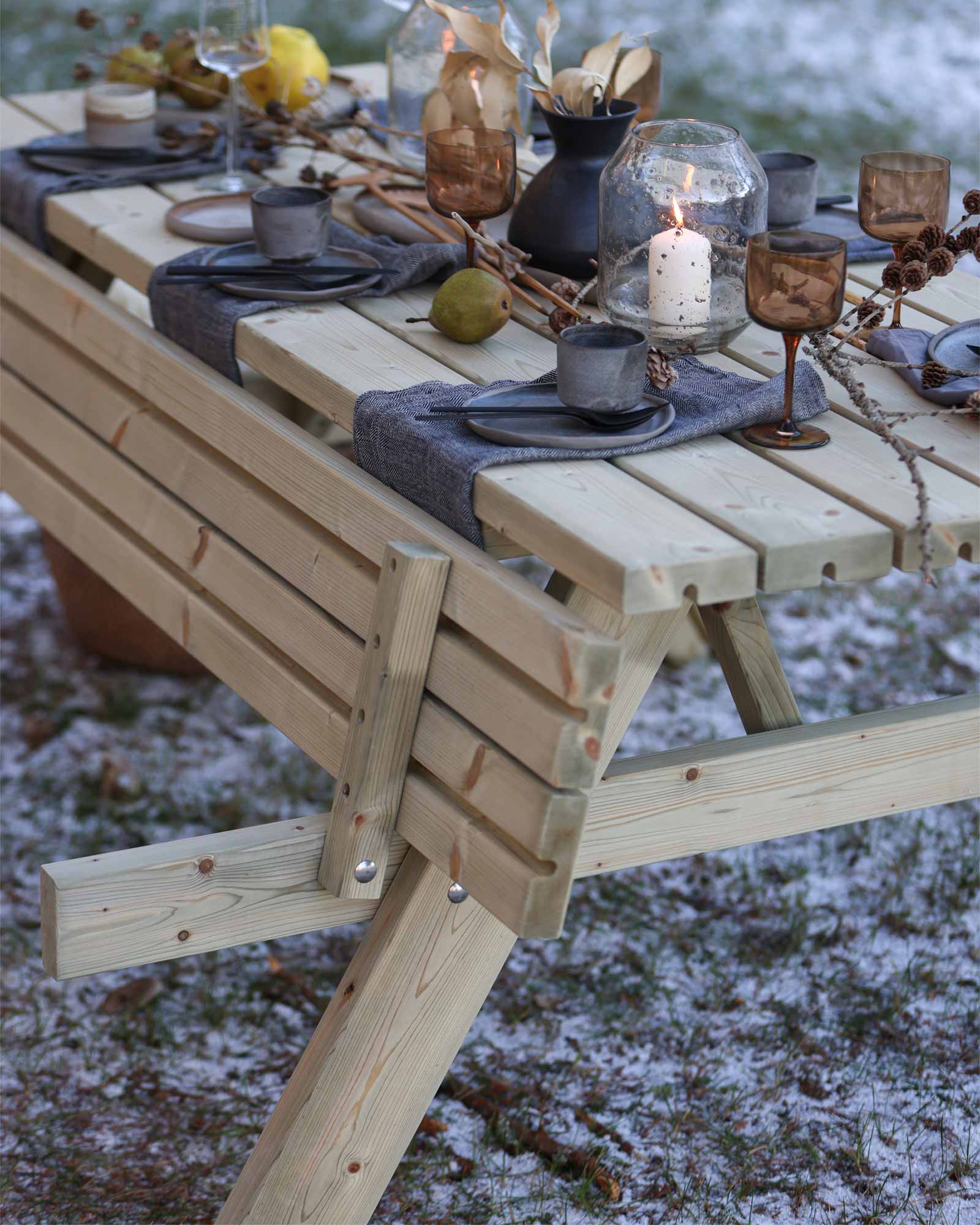 Beautifully set wooden picnic table in a frosty grass
