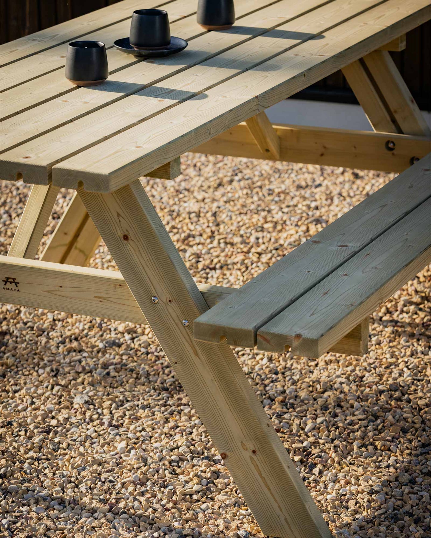Close up of green picnic table and 3 black coffee mugs