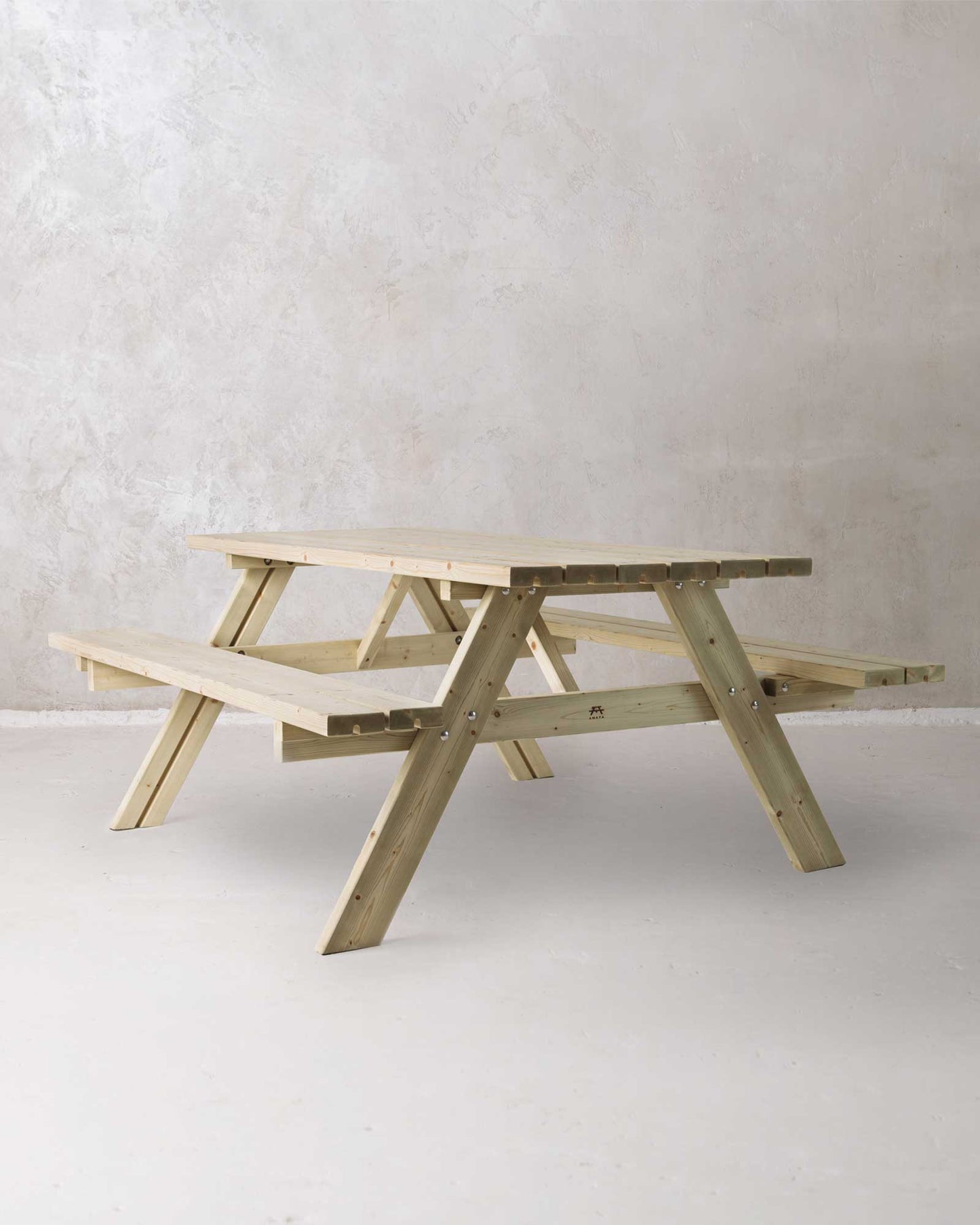 Green picnic table on a concrete background, slightly turned at an angle