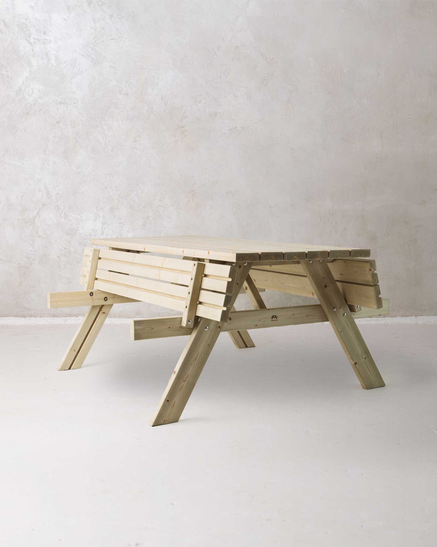 Green picnic table with folded benches on a concrete background, slightly turned at an angle