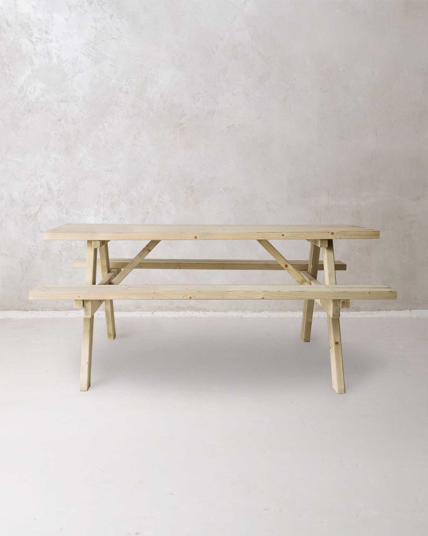 Green picnic table with folded benches on a grey concrete background