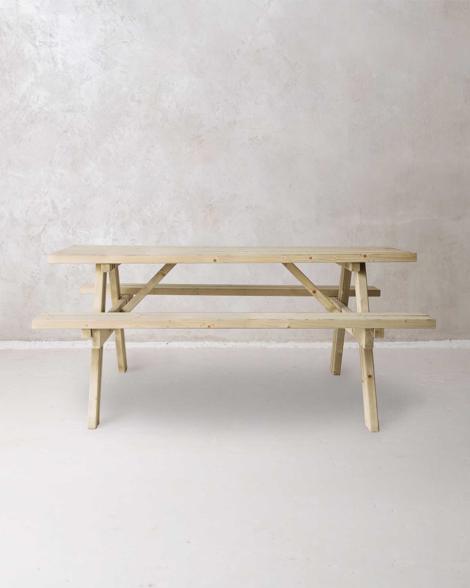 Green picnic table with folded benches on a grey concrete background