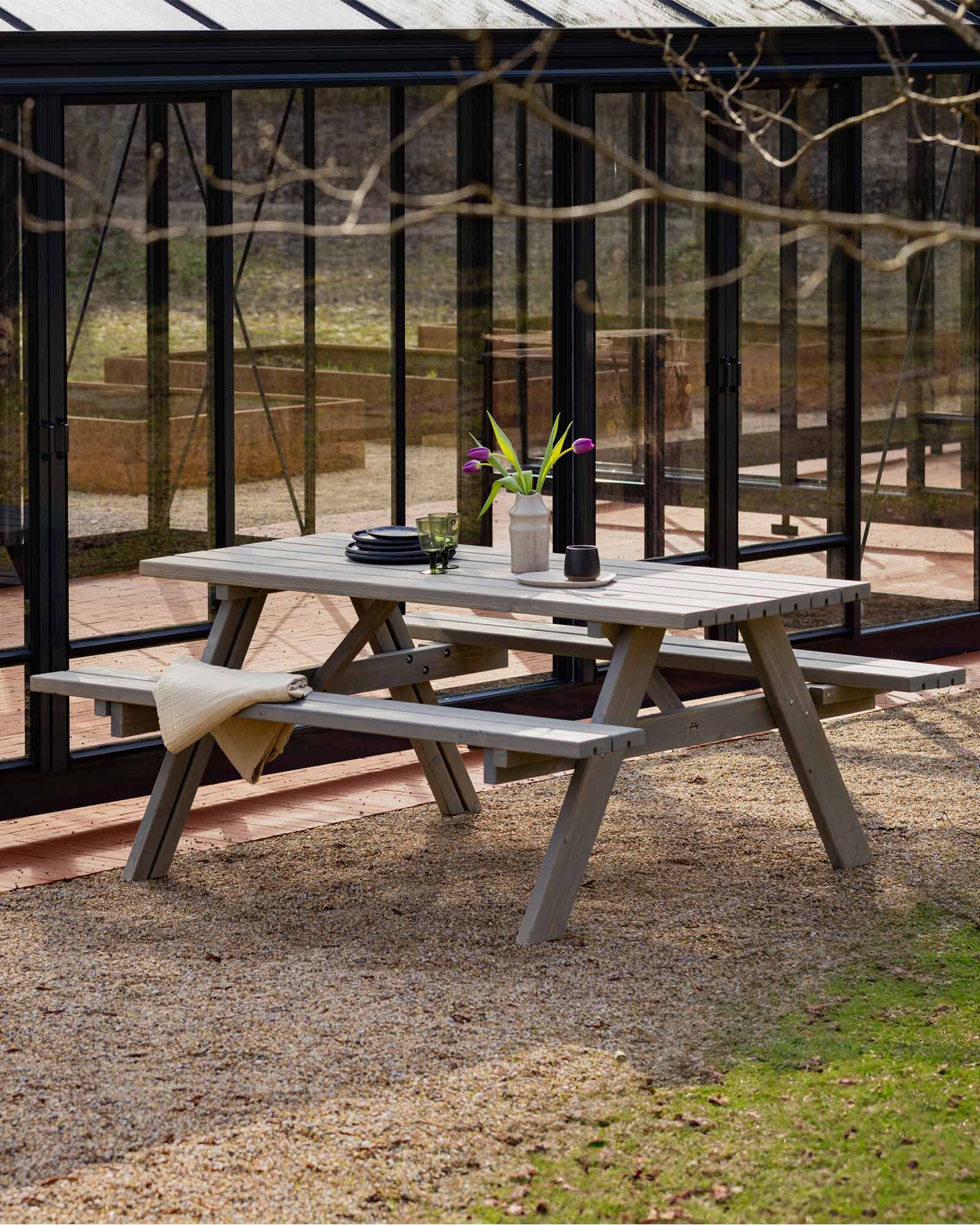 A dinner table next to a glass green house