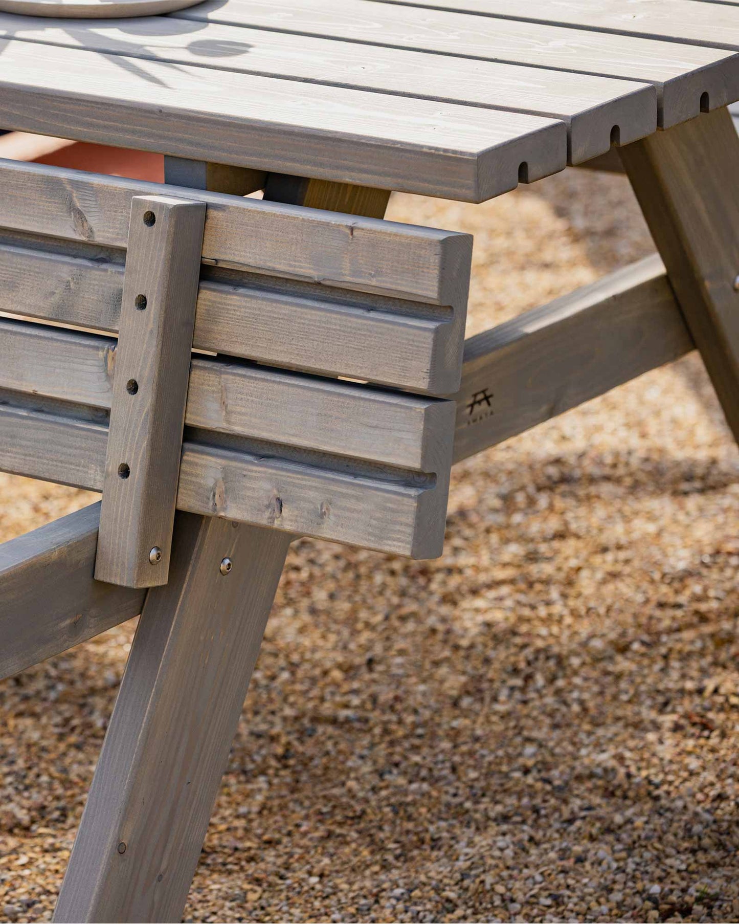 Grey picnic table on pebbles