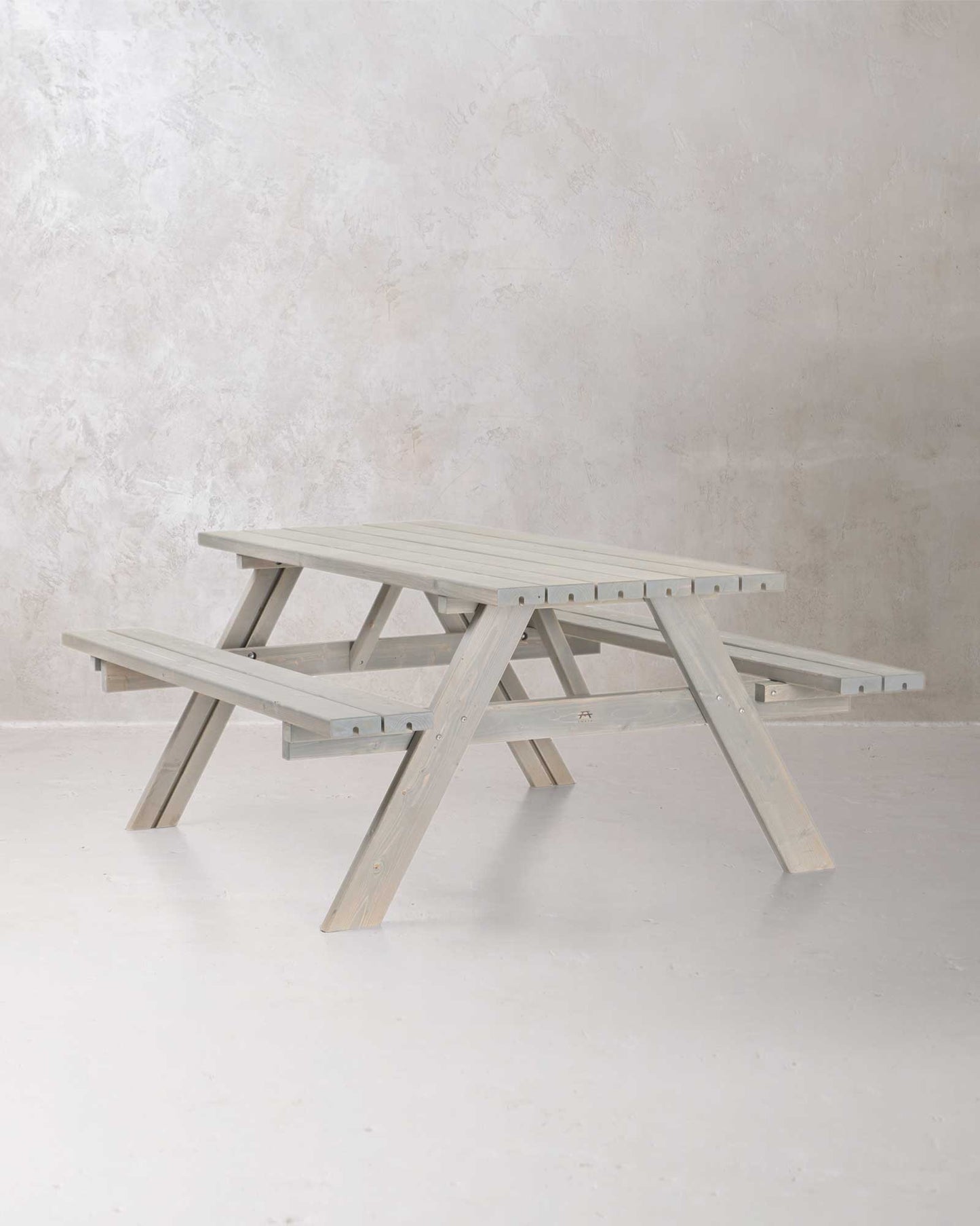 Grey picnic table on a concrete background, slightly angled