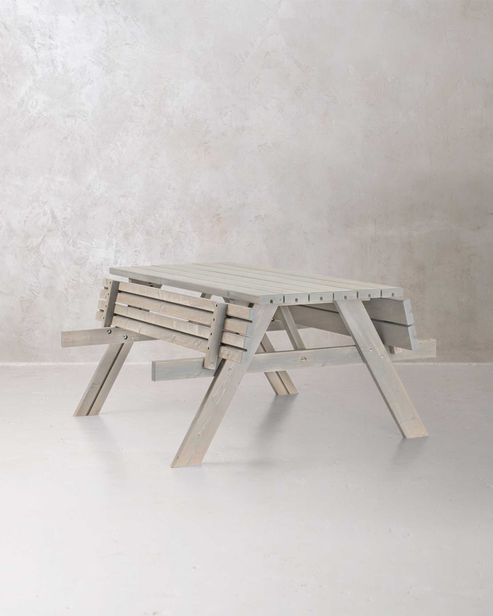 Grey picnic table with folded benches on a grey concrete background