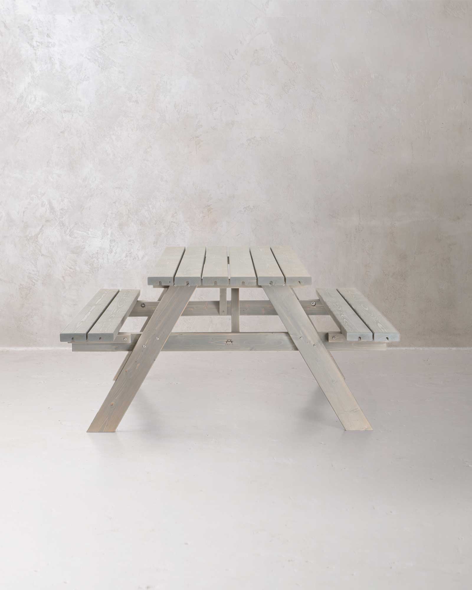 Grey picnic table on a concrete background