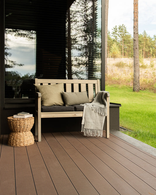 Grey wooden garden two seat bench on a house terrace