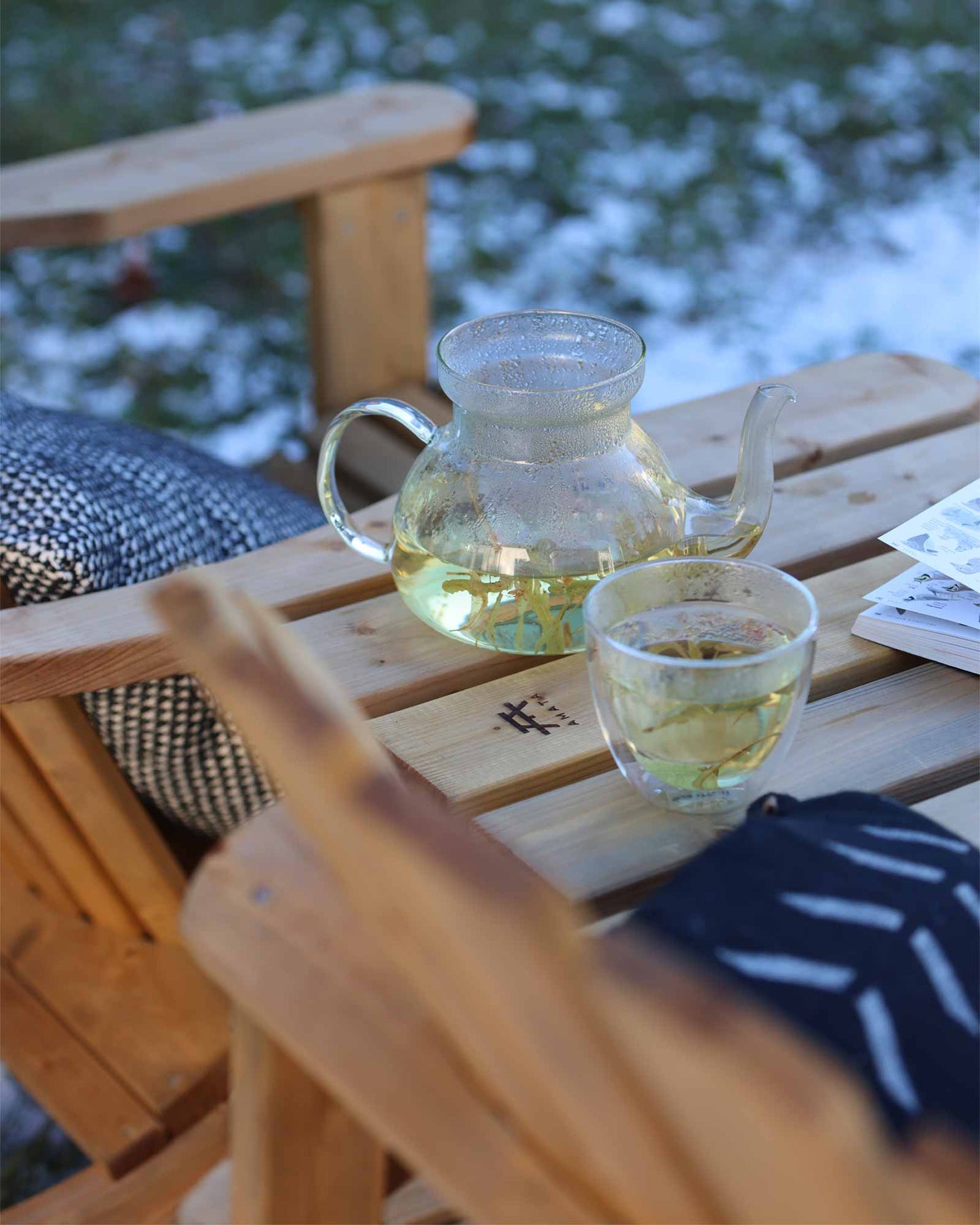 Closeup of the brown Adirondack double chair table with tea pot and cup