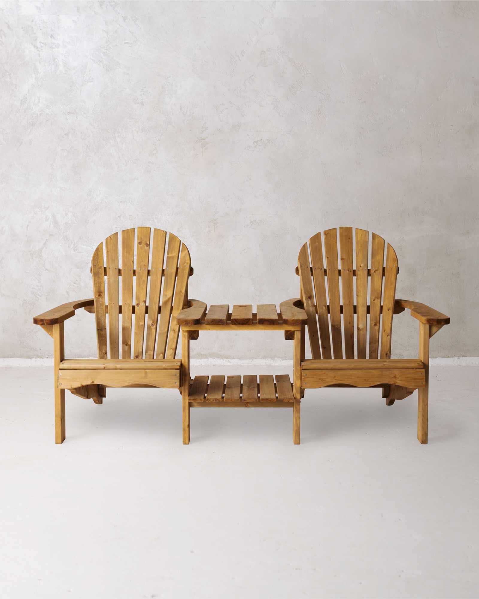 Double brown Adirondack chair on a concrete background photographed from the front