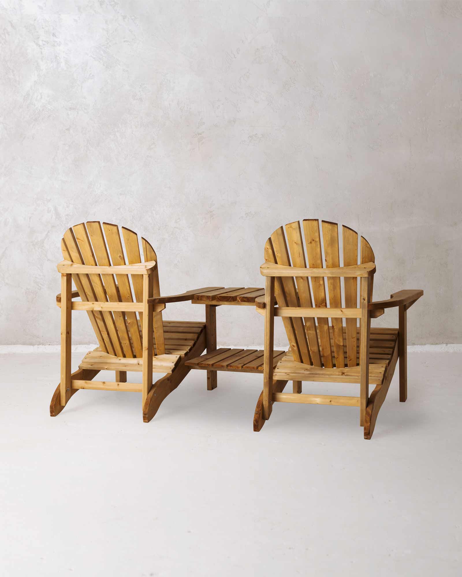 Double brown Adirondack chair on a concrete background photographed from the back