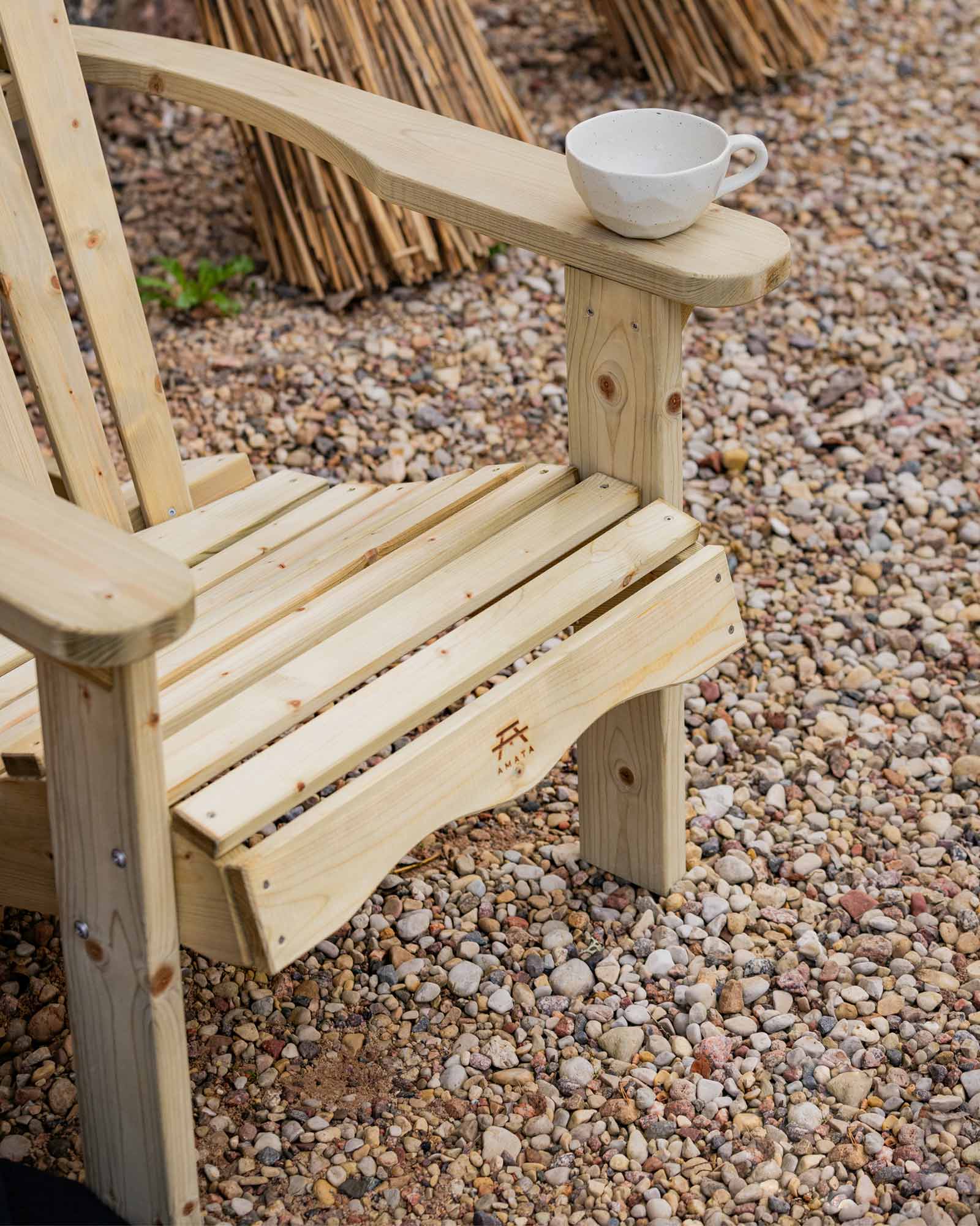 Green Adirondack garden chair on a small pebble garden floor