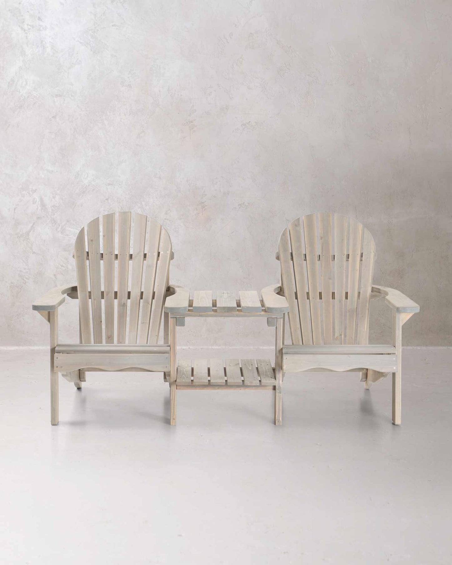 Double grey wooden Adirondack chair set on a concrete background, photographed from the front
