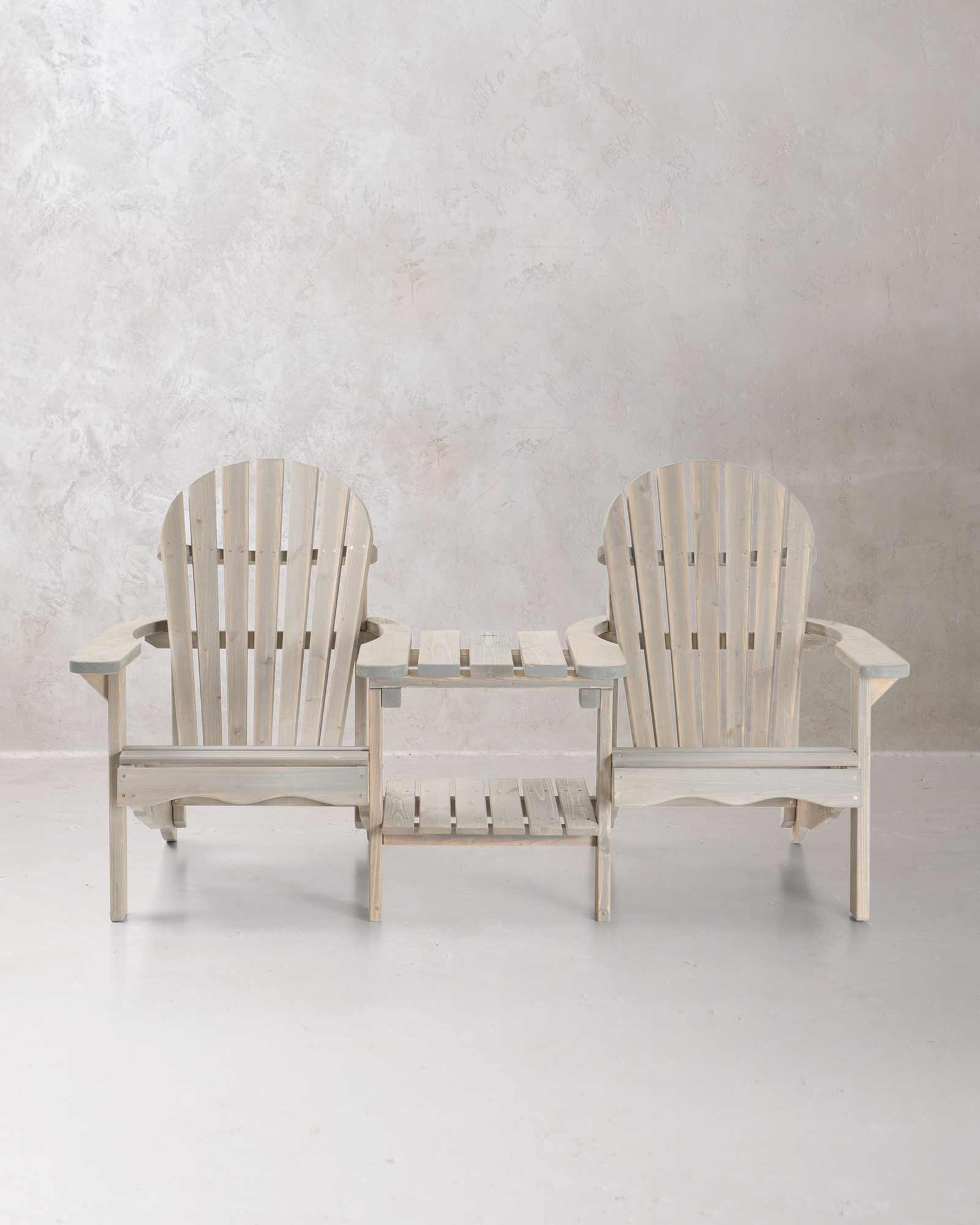 Double grey wooden Adirondack chair set on a concrete background, photographed from the front