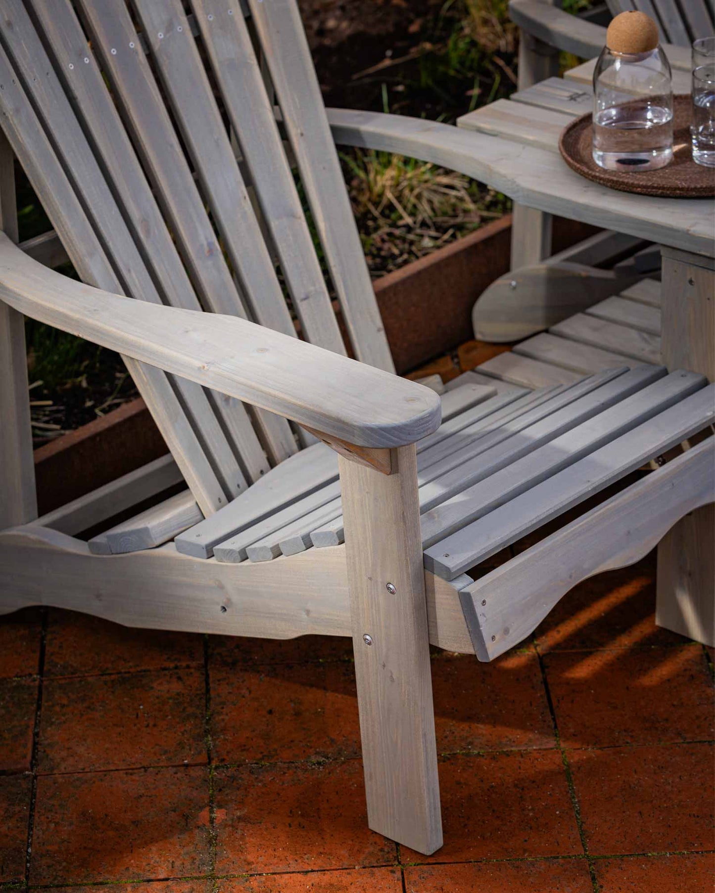 Closeup of the grey Adirondack chair's legs and fastenings