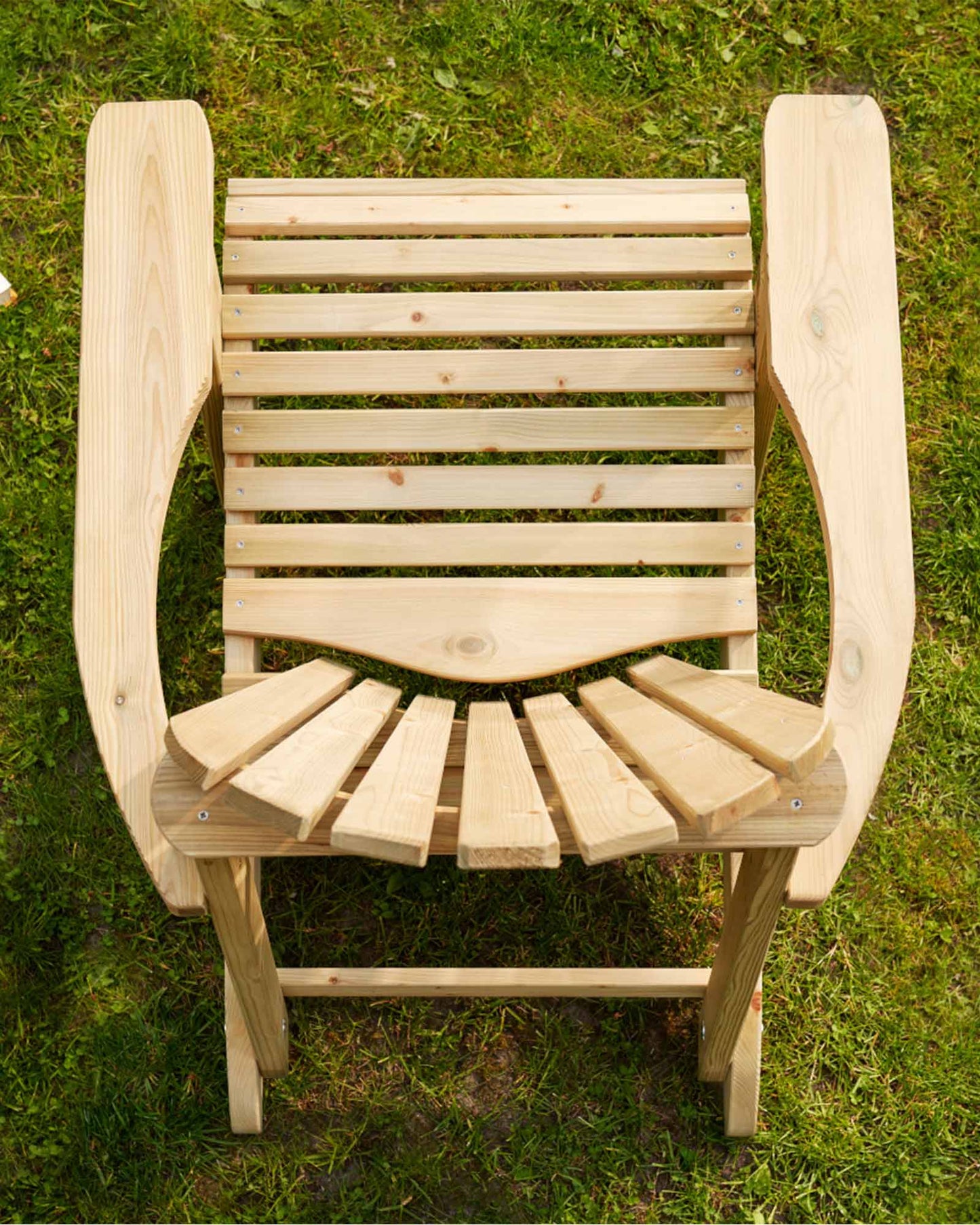 Green Adirondack chair photographed from above, sitting on the grass