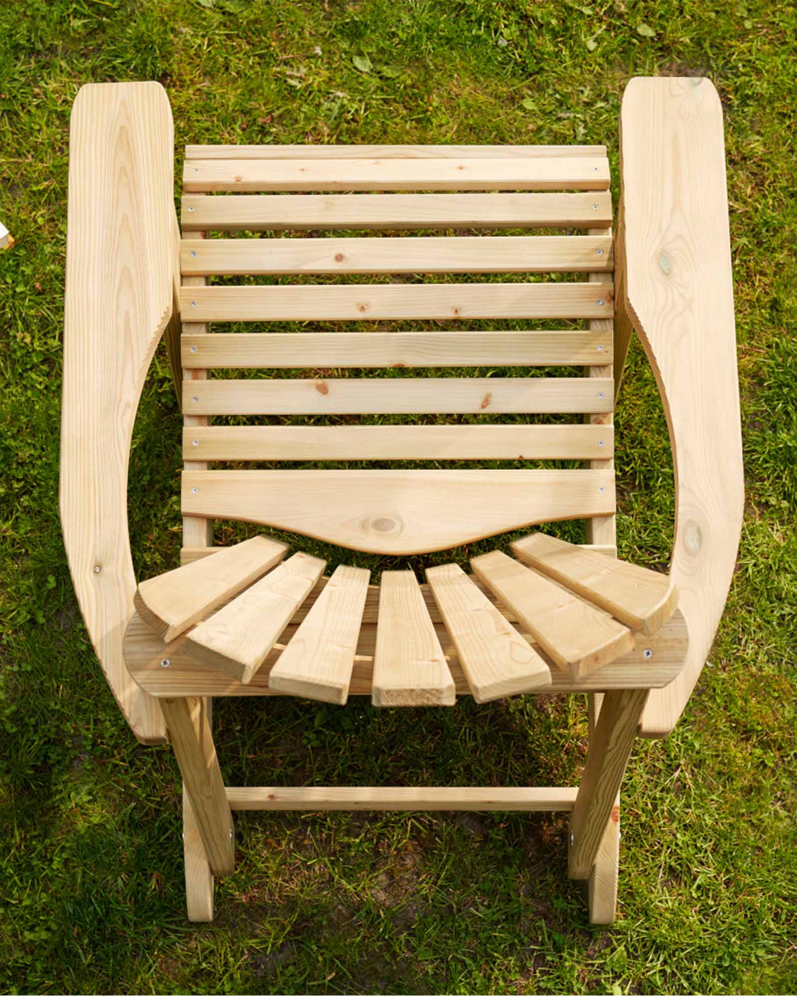 Green Adirondack chair photographed from above, sitting on the grass