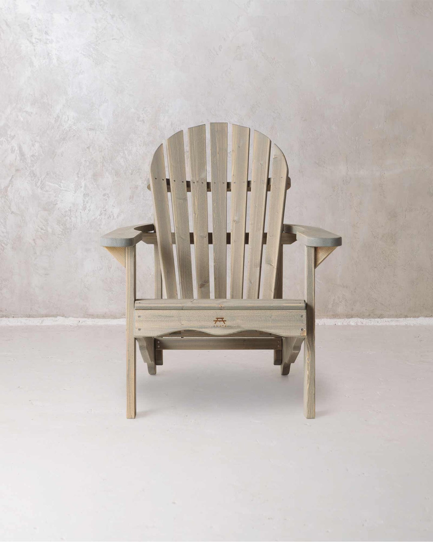 Grey wooden Adirondack chair on a concrete background, photographed from from the front