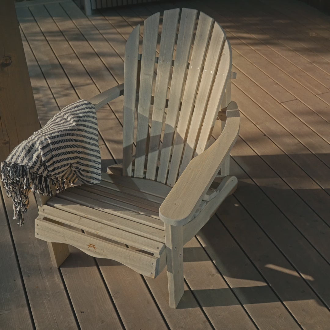 Girl sitting in an Adirondack wooden chair on a terrace