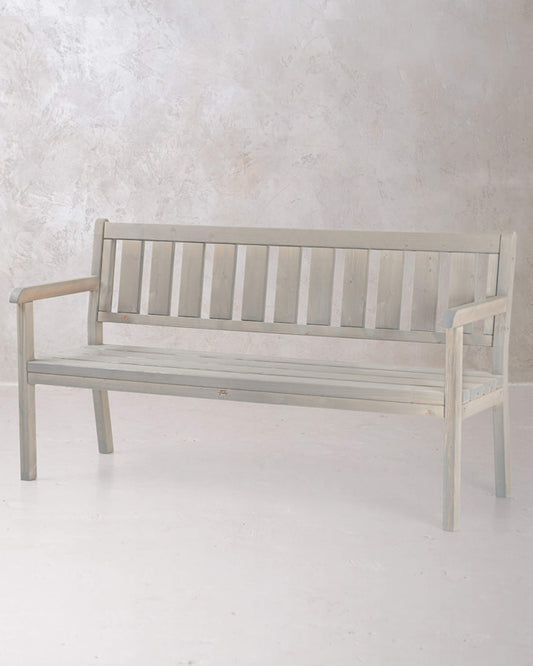 Grey wooden 3-seat bench chair on a concrete background, photographed from a slight angle