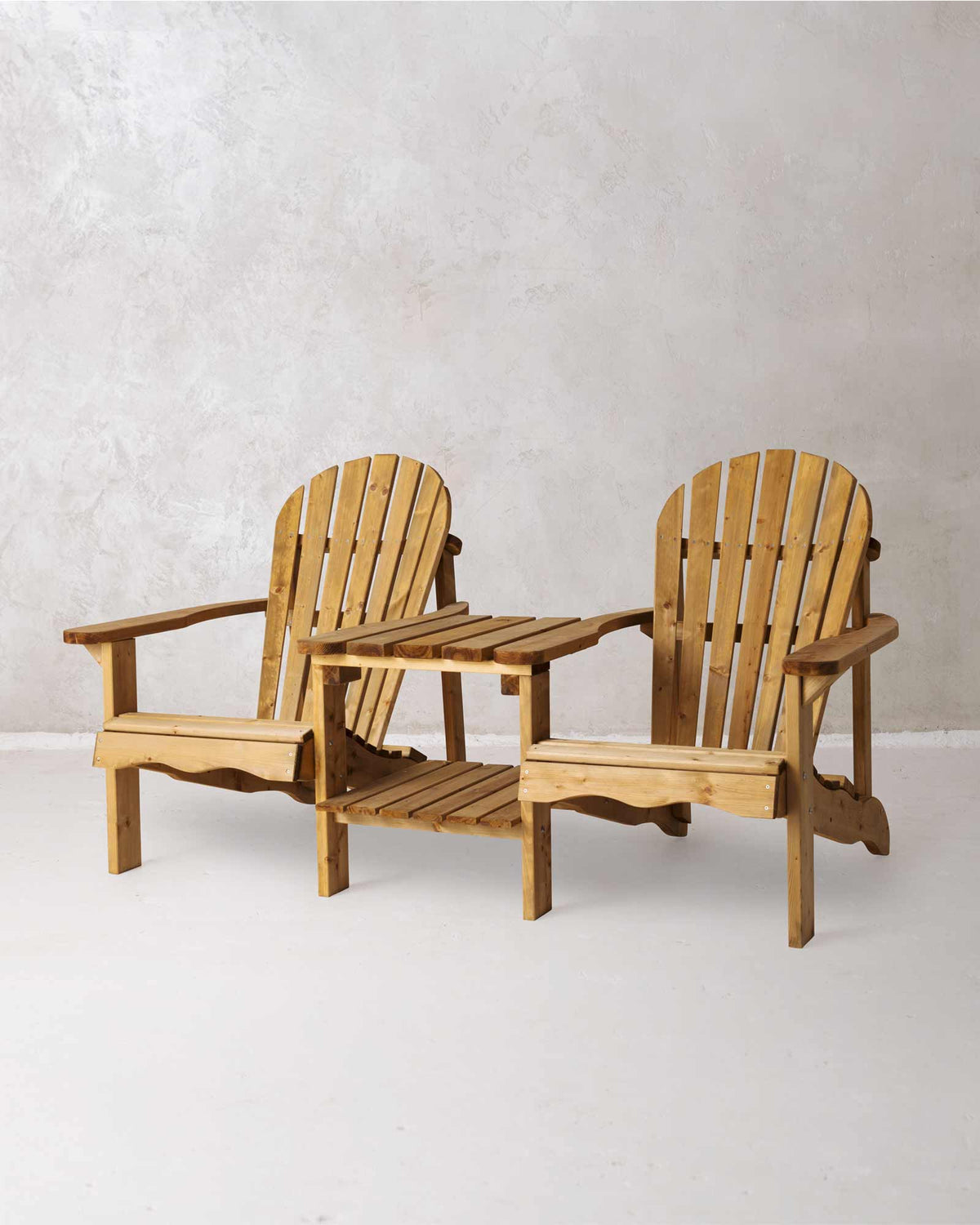 Double brown Adirondack chair on a concrete background photographed at a slight angle