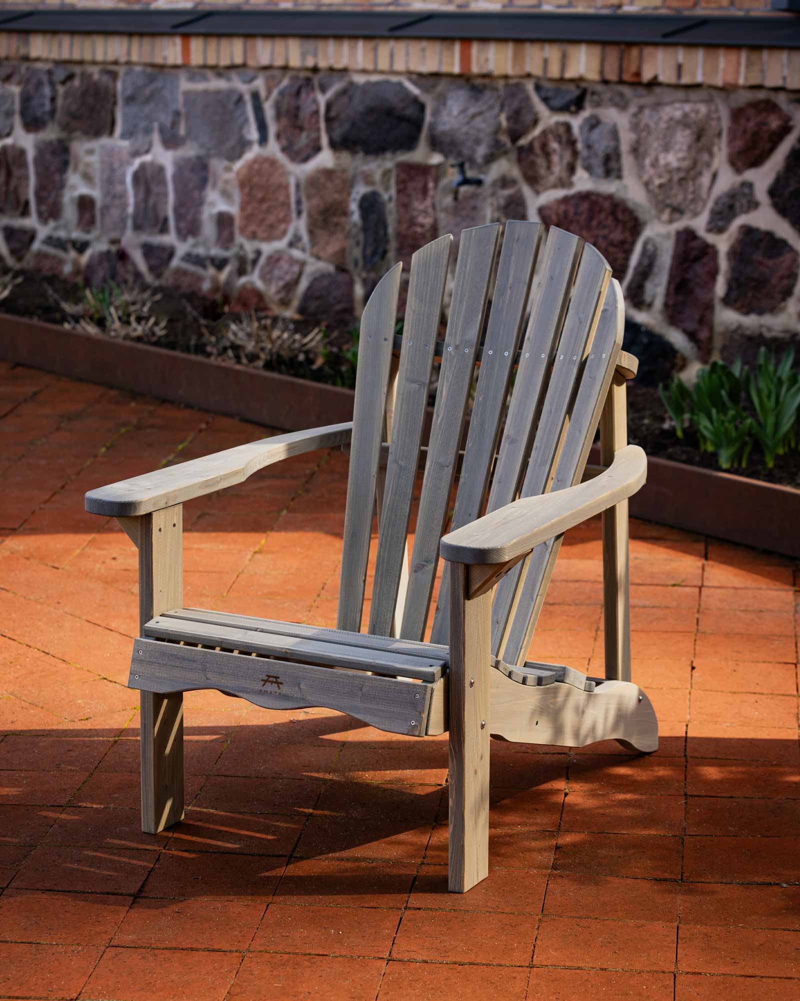 Grey Adirondack garden chair on a red brick tile patio