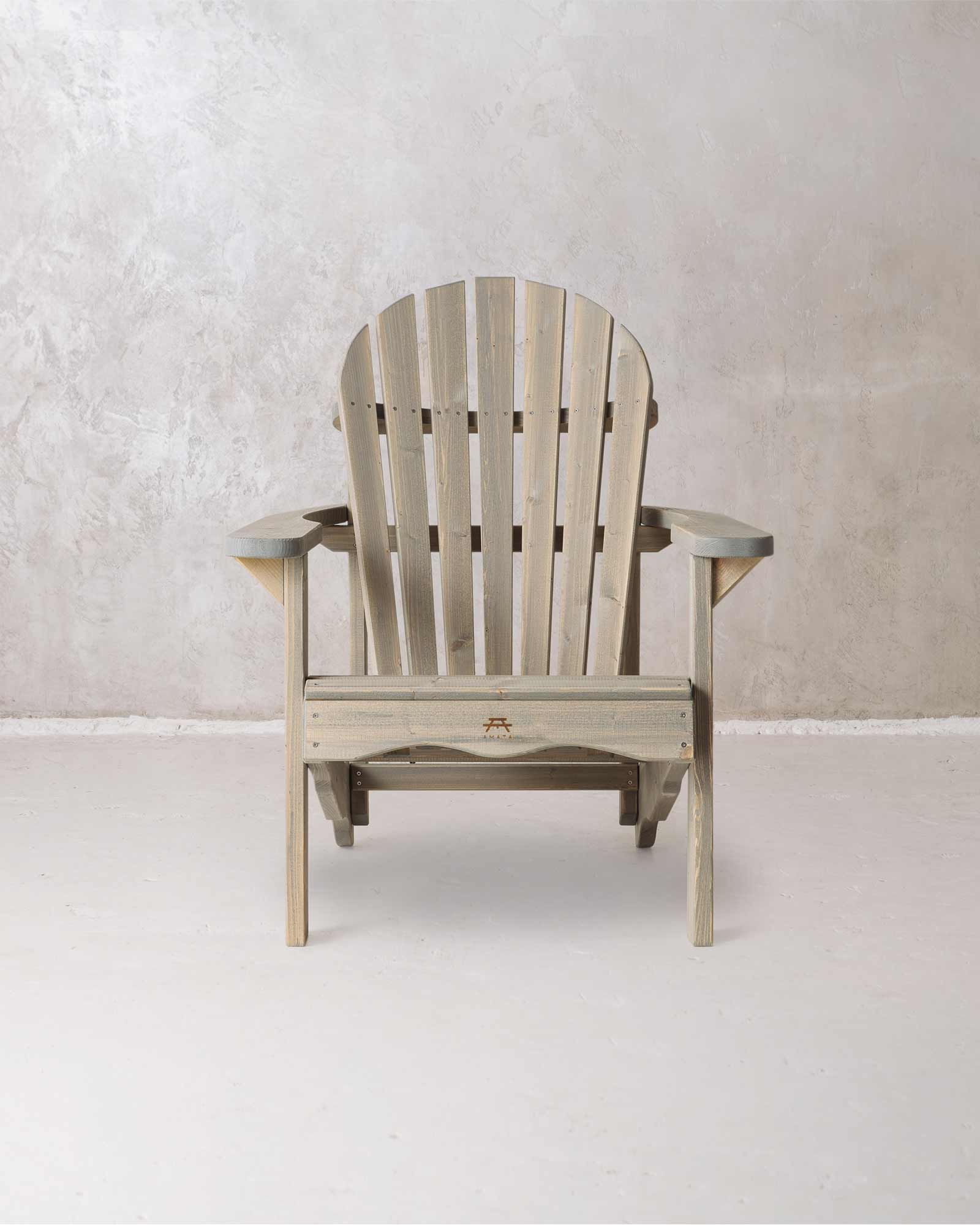 Grey wooden Adirondack chair on a concrete background, photographed from from the front