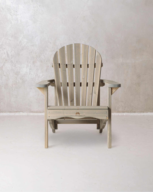 Grey wooden Adirondack chair on a concrete background, photographed from from the front